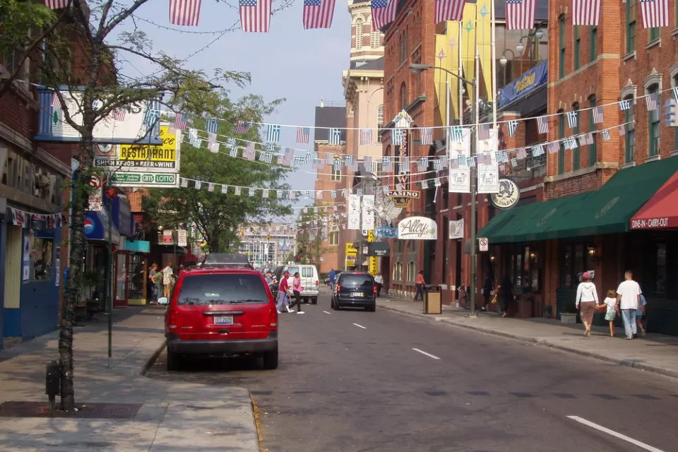 Two-lane street in Detroit's Greektown with American and Greek flags strung across the street